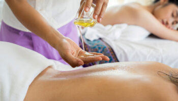 A person is getting oil applied to their back.