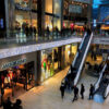 A group of people walking around an indoor mall.