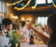 A group of people sitting at tables with wine glasses.