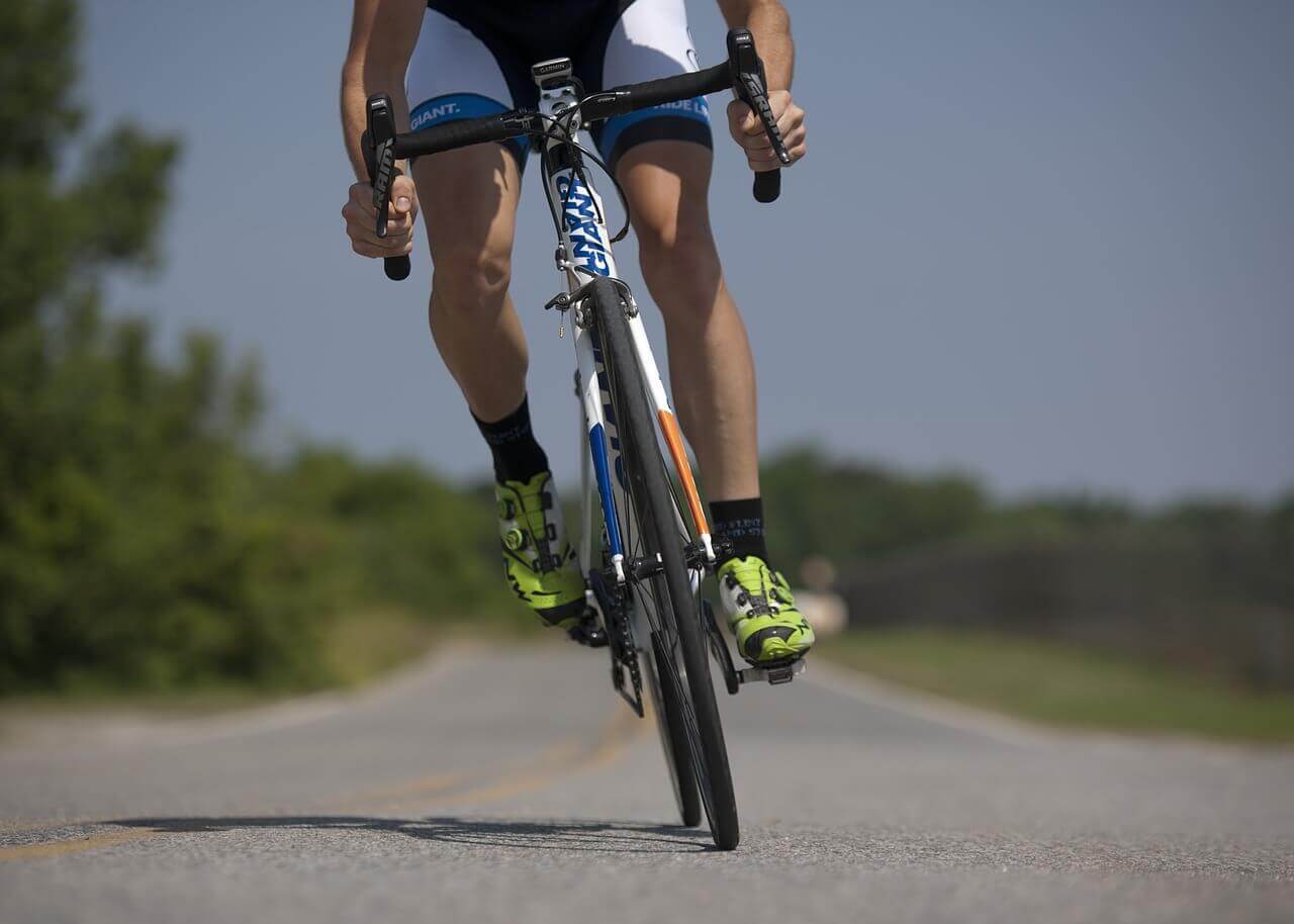 A person riding a bike on the side of a road.
