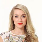 A woman with long blonde hair and bright red lipstick.