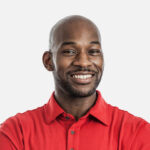 A man in red shirt smiling for the camera.