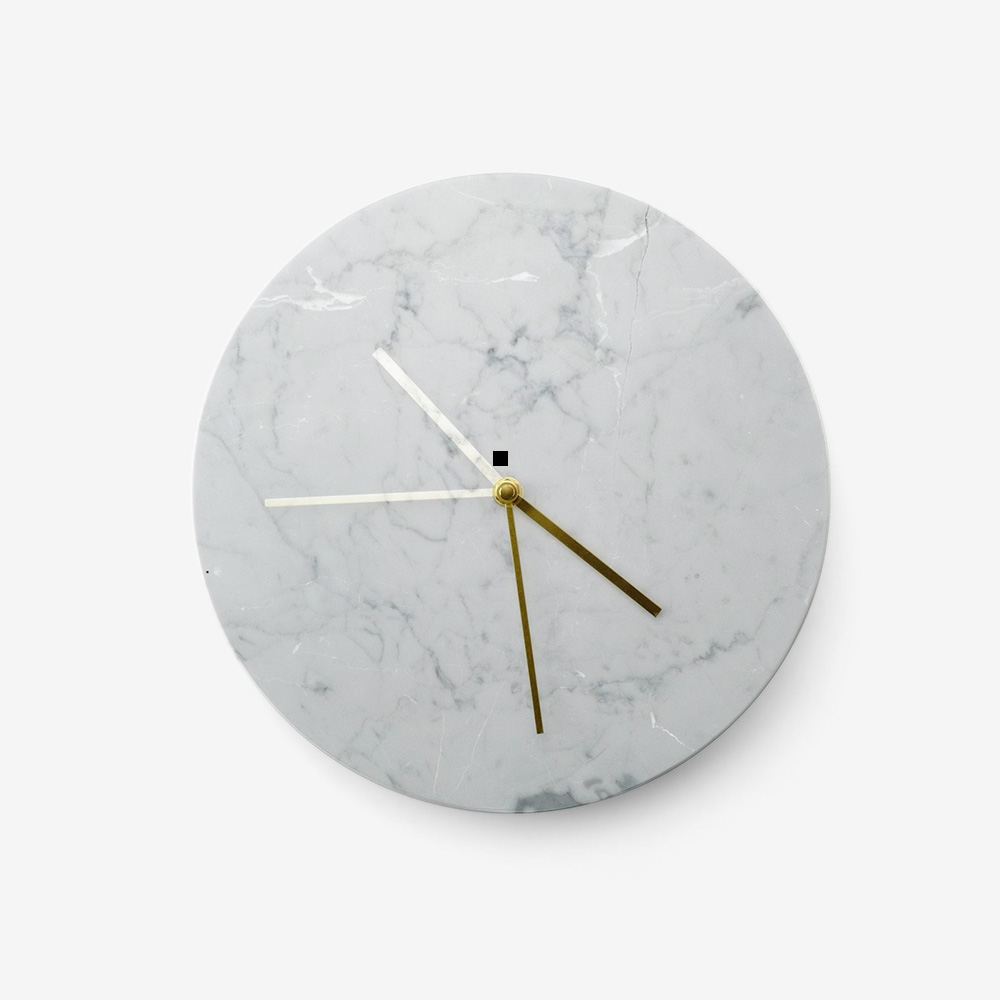 A clock with a marble face and gold hands.