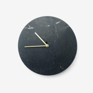 A black clock with gold hands on top of it.