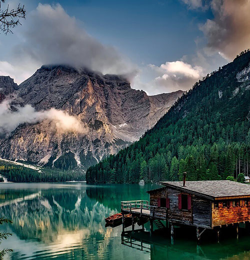 A lake with mountains in the background and clouds above.