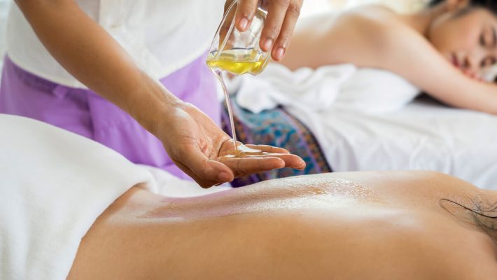 A person is getting oil applied to their back.