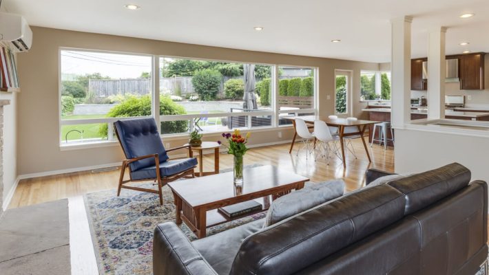 A living room with a couch, chairs and table.