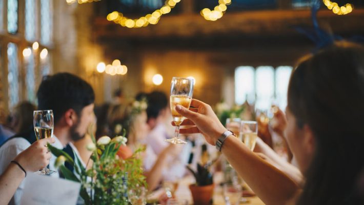 A group of people sitting at tables with wine glasses.